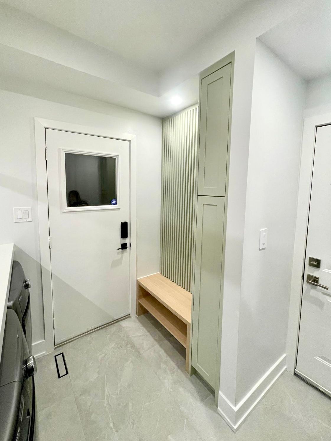 Custom sage green laundry room and mudroom cabinetry