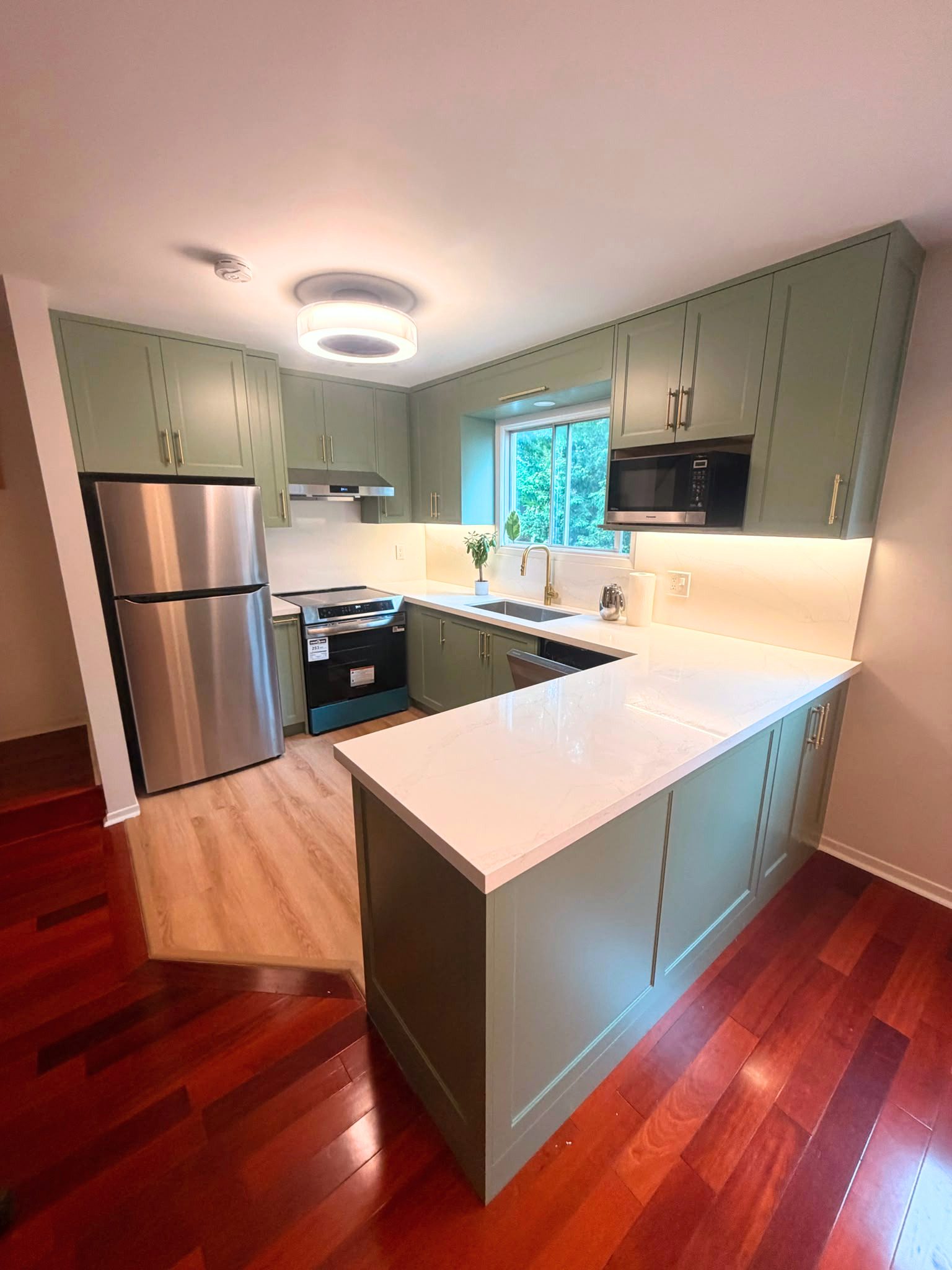 North York kitchen renovation full view with sage green cabinets, gold hardware, and new flooring
